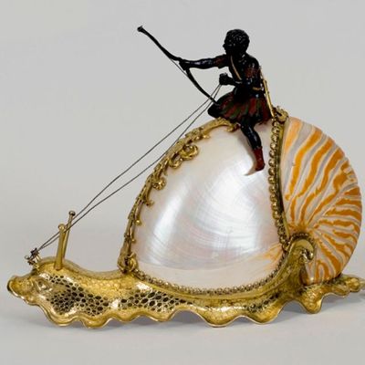 A figurine of a man riding on a snail
