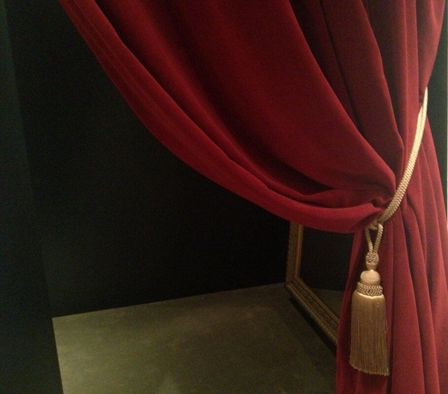 A red curtain with a tassel hanging from it.