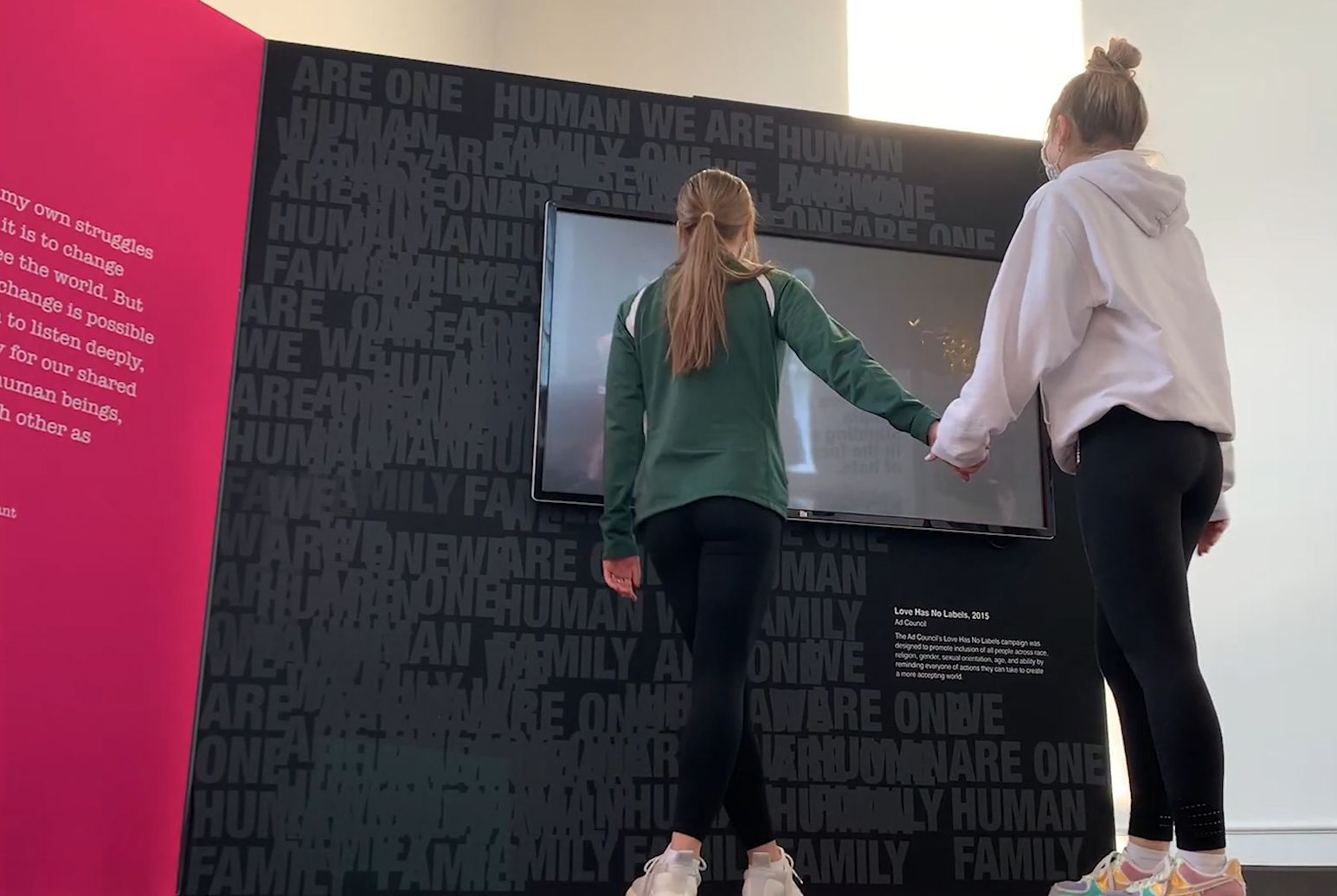 Two women by a screen