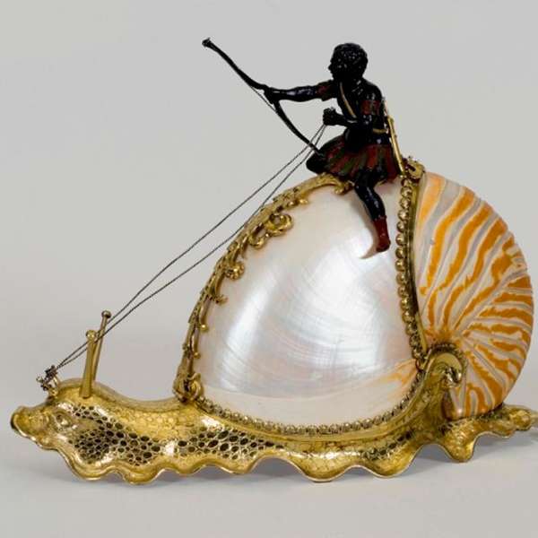 A figurine of a man riding on a snail