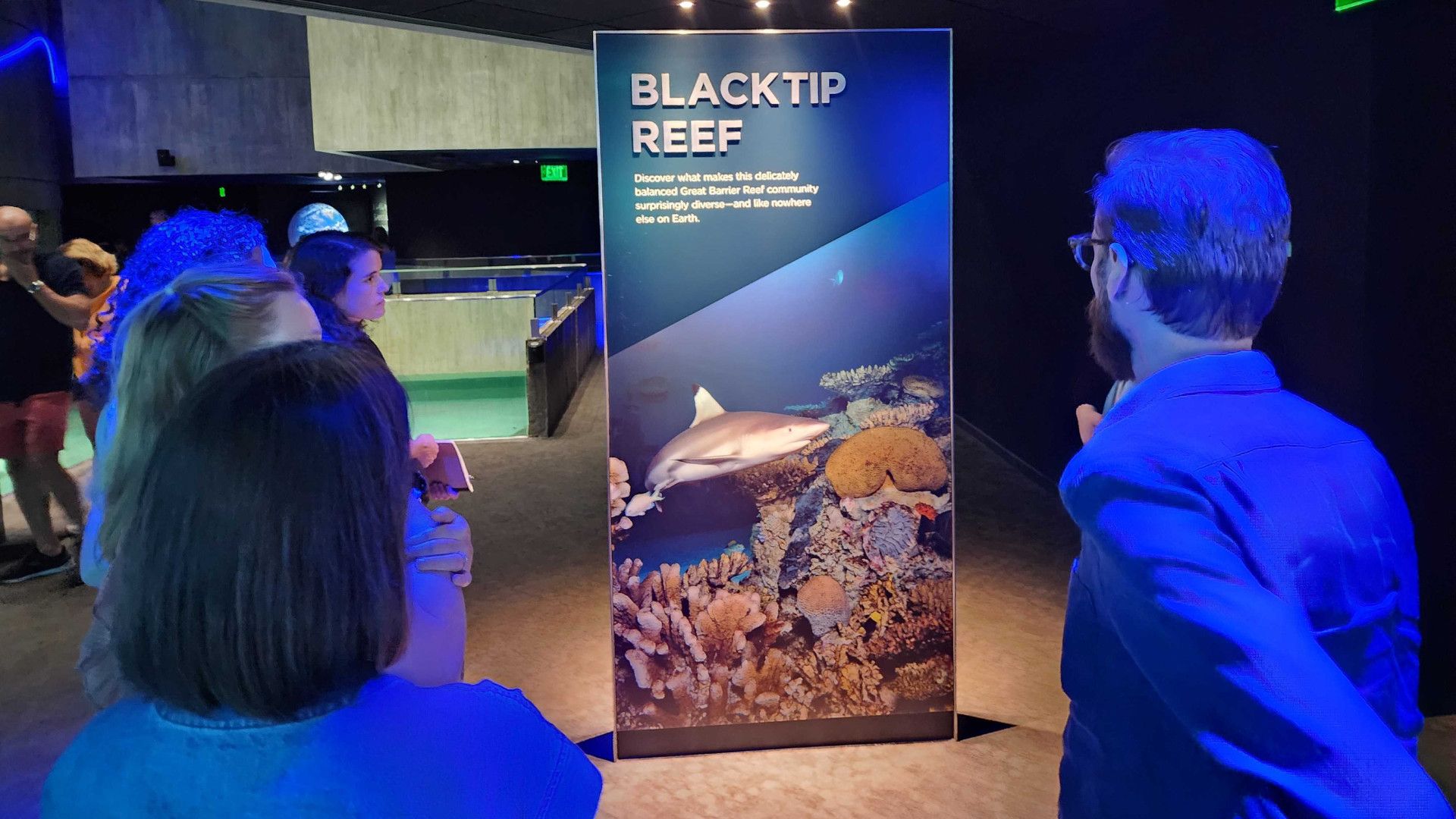 A man looking at an aquarium sign.