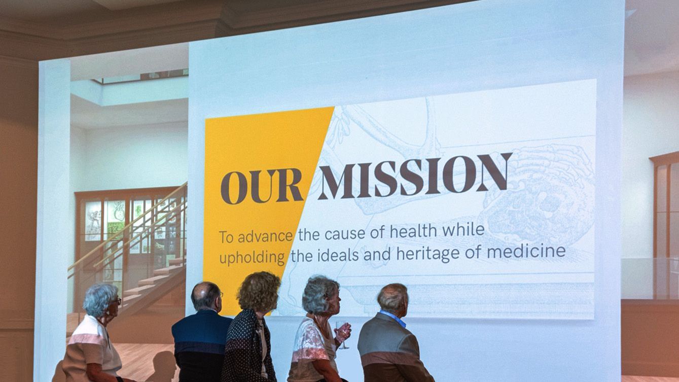 A group of people standing in front of the projection screen.